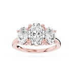 Rose gold oval shaped lab grown diamond trilogy ring featuring three prong set diamonds with a raised center stone