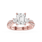 Rose gold ring with emerald-cut diamond and smaller diamonds on a white background