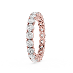 A rose gold eternity ring featuring a continuous row of round brilliant-cut clear diamonds on a white background.