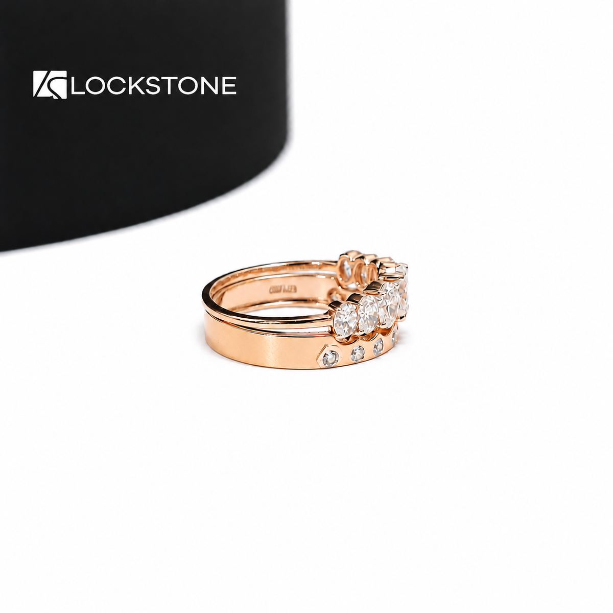 Rose gold oval diamond bridal ring set featuring prong set center stones and a matching band with spaced bezel diamonds