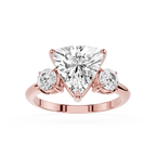 Rose gold ring with a heart-shaped diamond and two round diamonds on a white background