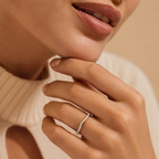 Close-up of a hand wearing a diamond ring with a blurred background