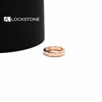 Three east west emerald cut diamonds sit across the front of this rose gold anniversary ring with a wide polished band