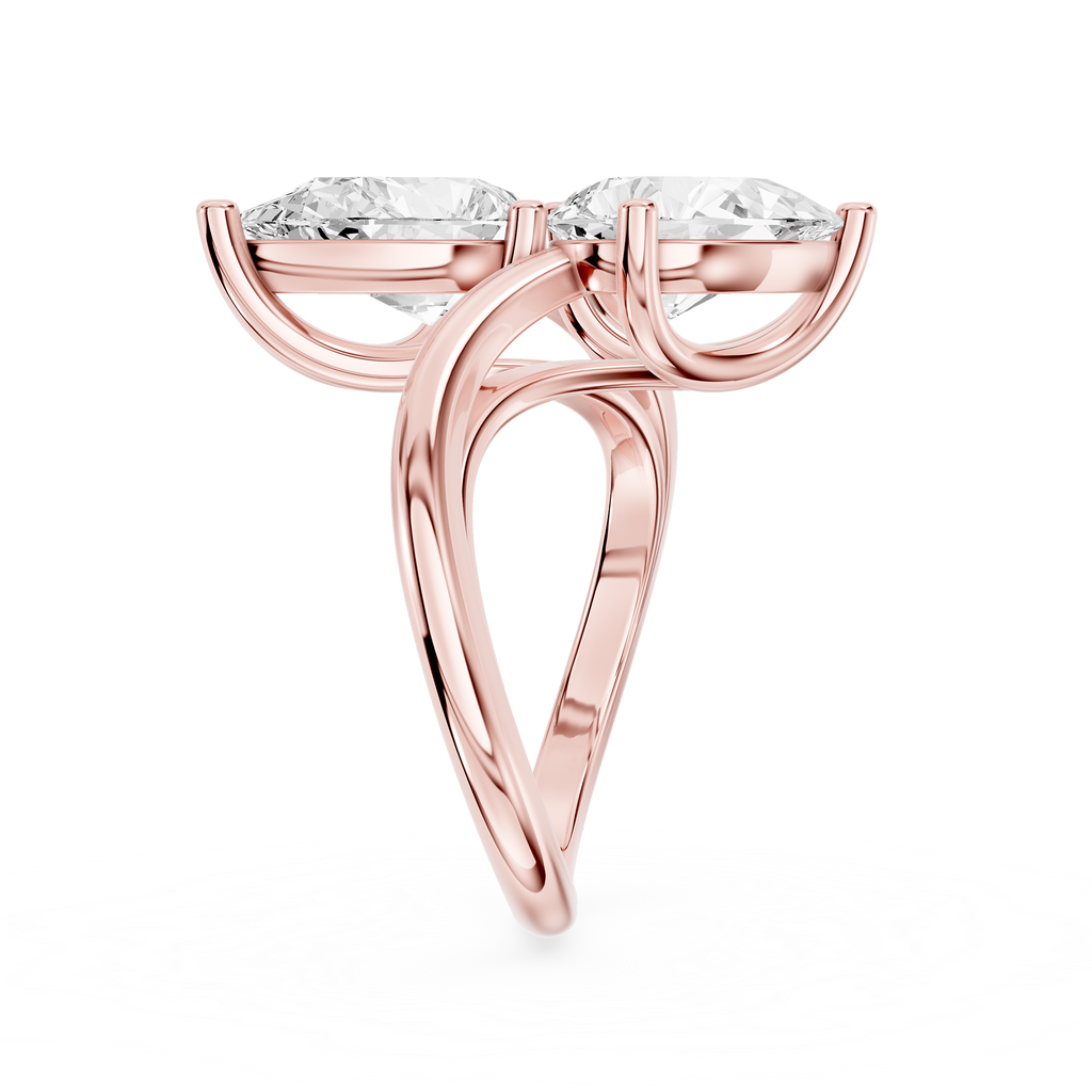 A pair of pear cut diamonds sits diagonally on this rose gold engagement ring with a curved open band setting