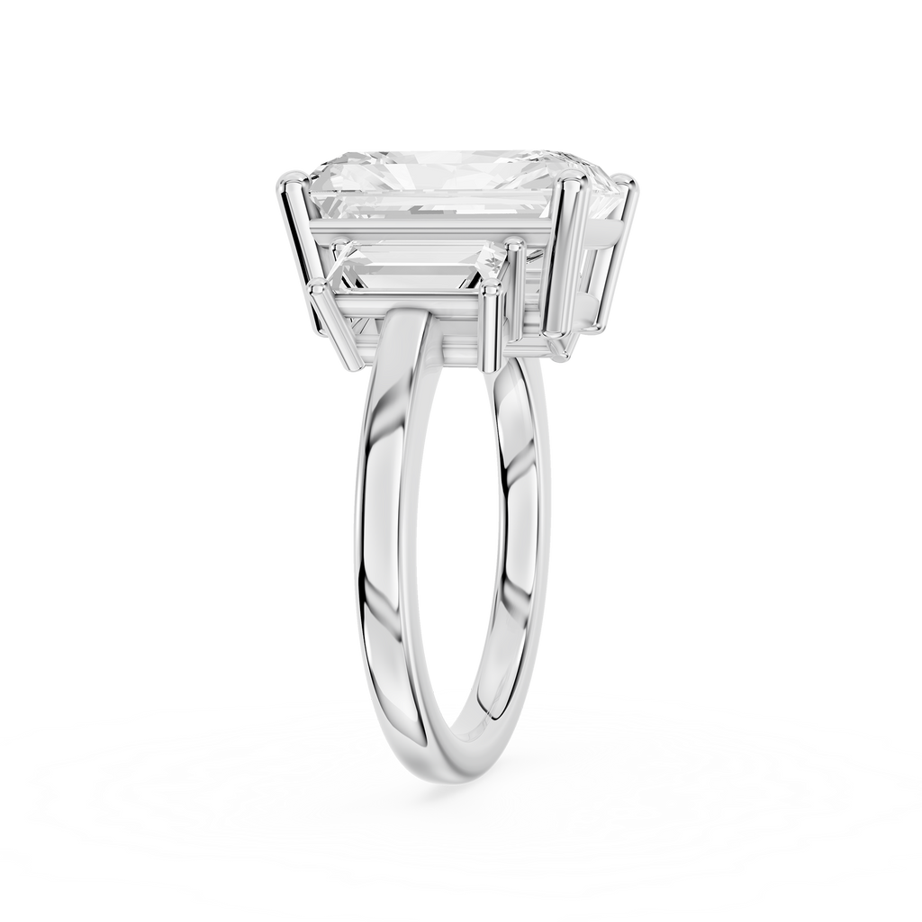 Tapered baguette diamonds frame a rectangular radiant cut center stone on this polished white gold engagement ring