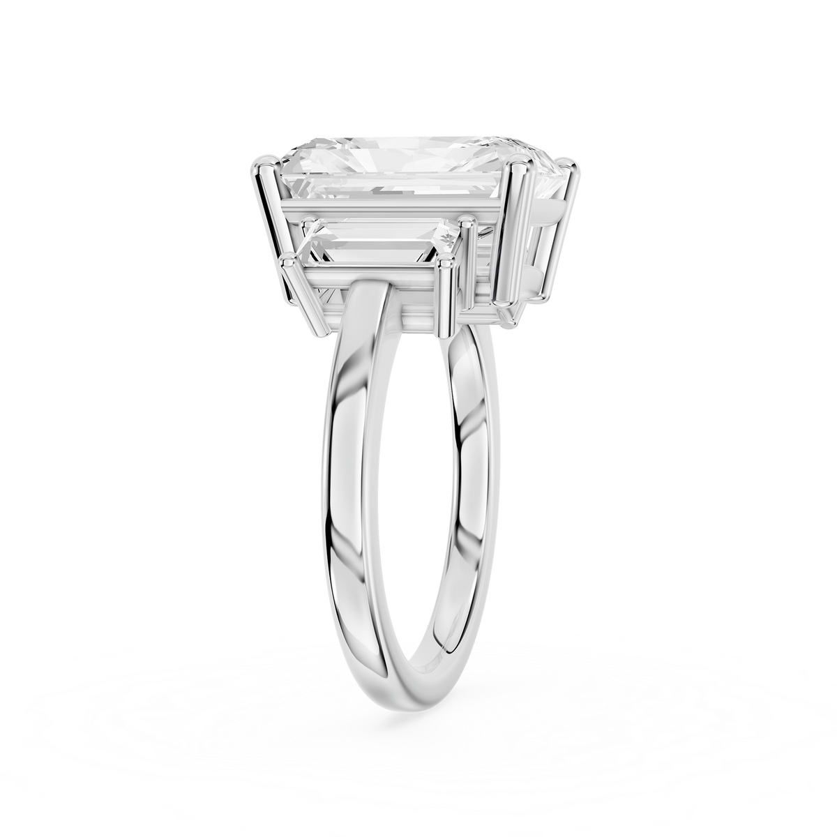 Tapered baguette diamonds frame a rectangular radiant cut center stone on this polished white gold engagement ring