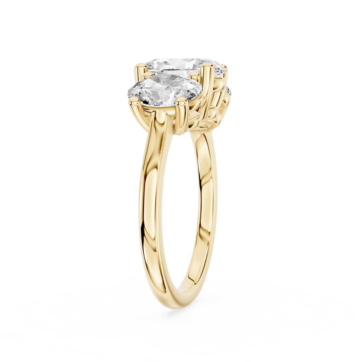 Three oval shaped lab diamonds sit across a polished yellow gold band with graduated sizes and individual prong settings