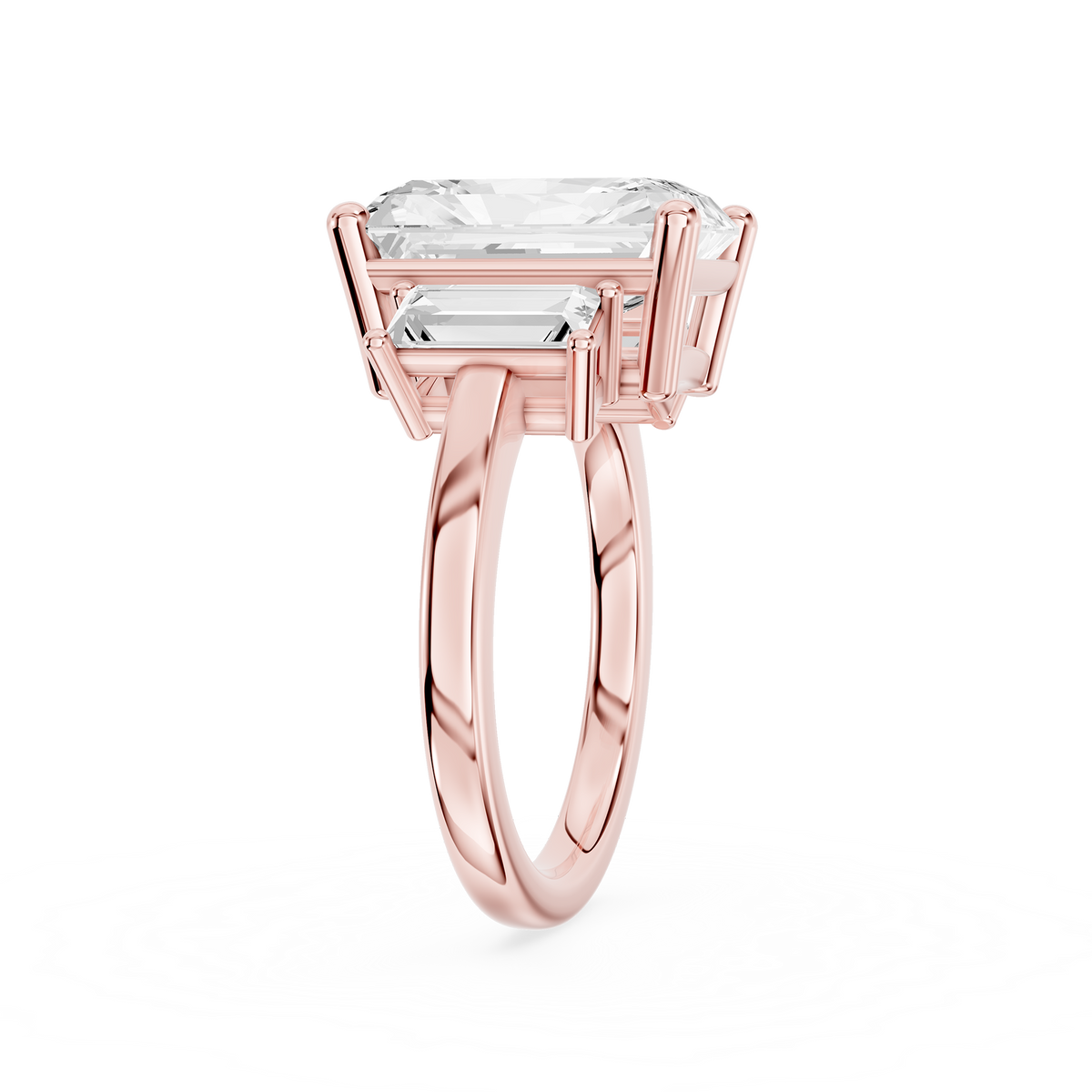 Three stone diamond engagement ring in rose gold showcasing a rectangular radiant diamond flanked by step cut side stones