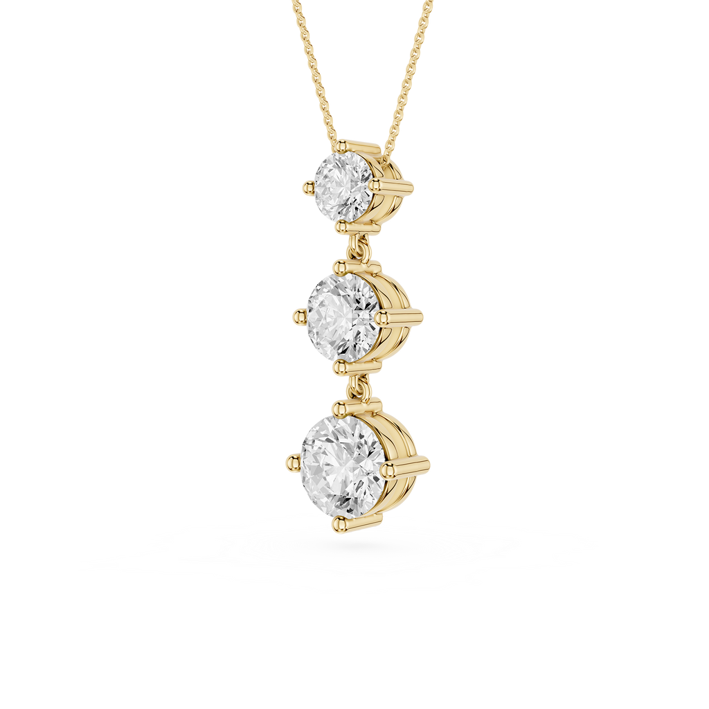 Gold necklace with three diamond pendants on a white background