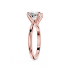 Rose gold ring with a clear gemstone on a white background