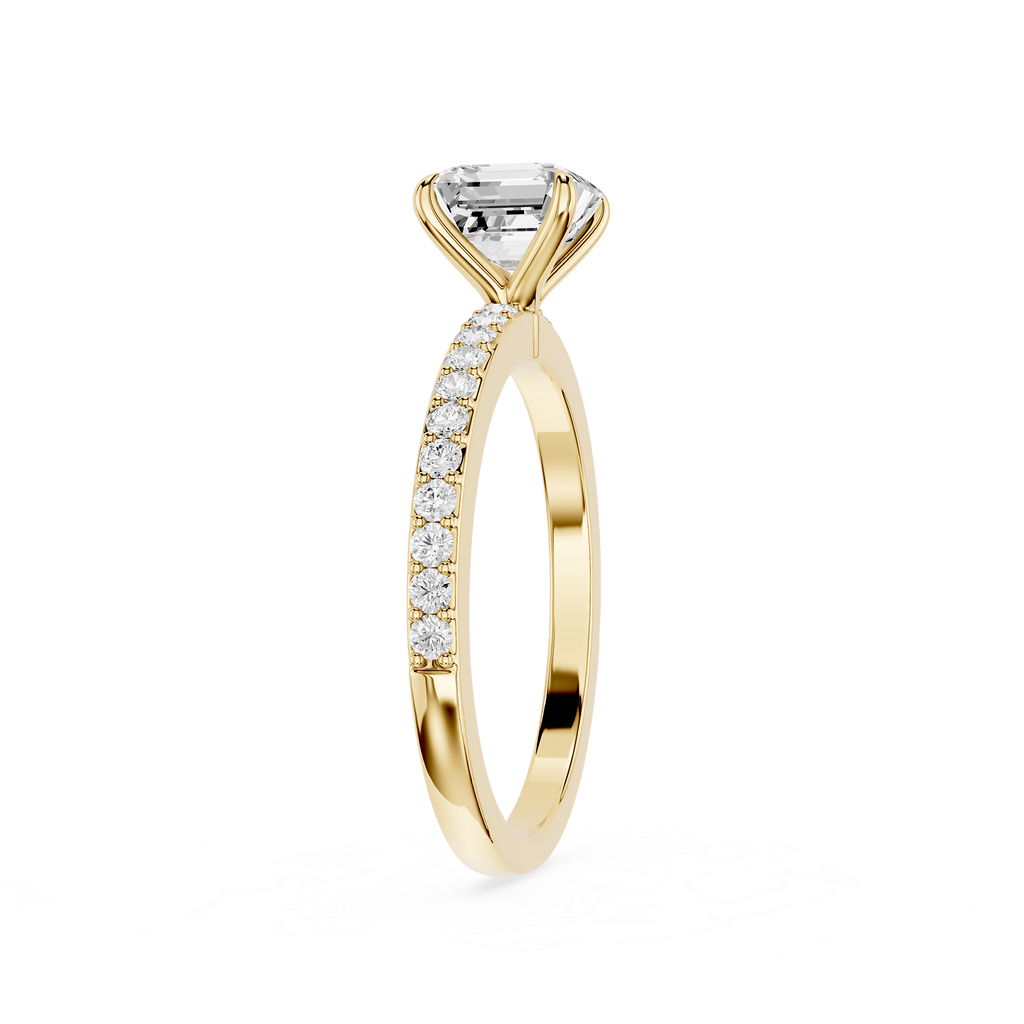 A yellow gold engagement ring featuring a large rectangular emerald-cut diamond center stone and a pavé band set with small round diamonds, shown on a plain white background.