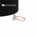 A vertically set marquise shaped diamond sits on a slim engagement ring with small round diamonds along the shoulders