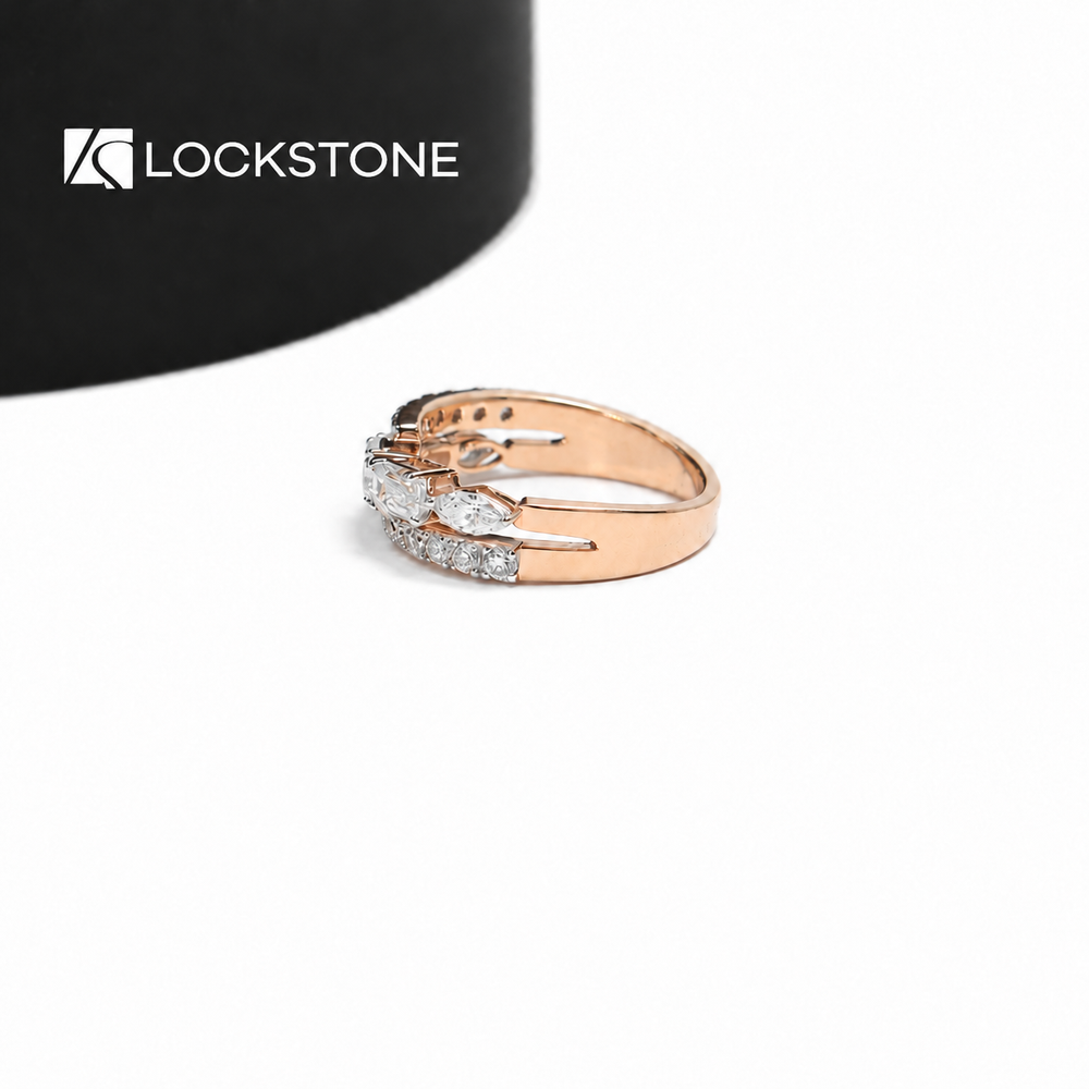 An oval diamond sits between rectangular step cut stones on this rose gold ring with curved rows of round diamond accents