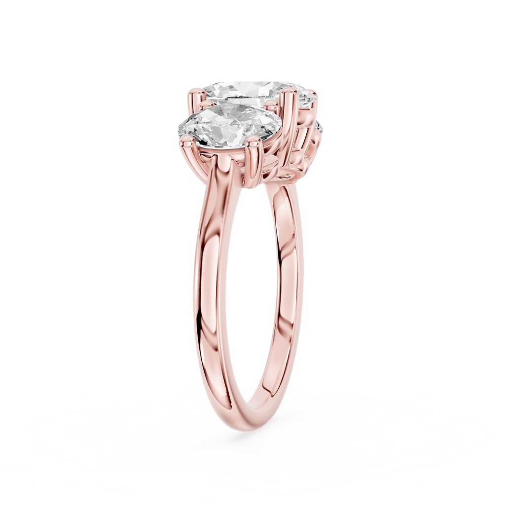 A larger oval diamond sits between two smaller oval cut stones on this rose gold three stone engagement ring