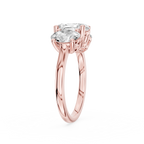 A larger oval diamond sits between two smaller oval cut stones on this rose gold three stone engagement ring
