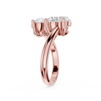 A rose gold diamond ring with a split-shank band and a three-stone crown, shown on a clean white background.
