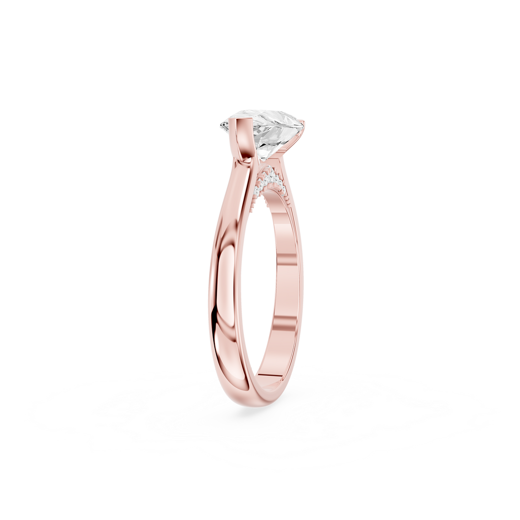 Pear shaped diamond engagement ring in rose gold featuring a sideways center stone held by a curved crescent bezel