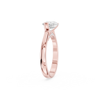 Pear shaped diamond engagement ring in rose gold featuring a sideways center stone held by a curved crescent bezel