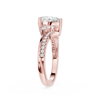 A rose gold diamond ring with a round-cut center stone and pavé-set diamonds along the shank, shown on a clean white background.