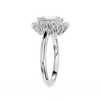 A silver-toned halo ring featuring a rectangular emerald-cut center stone and a surrounding cluster of smaller stones, shown on a plain white background.