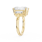Rectangular radiant diamond three stone ring in yellow gold with two tapered baguette diamonds beside the center stone