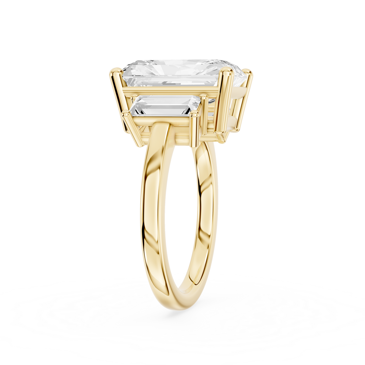 Rectangular radiant diamond three stone ring in yellow gold with two tapered baguette diamonds beside the center stone