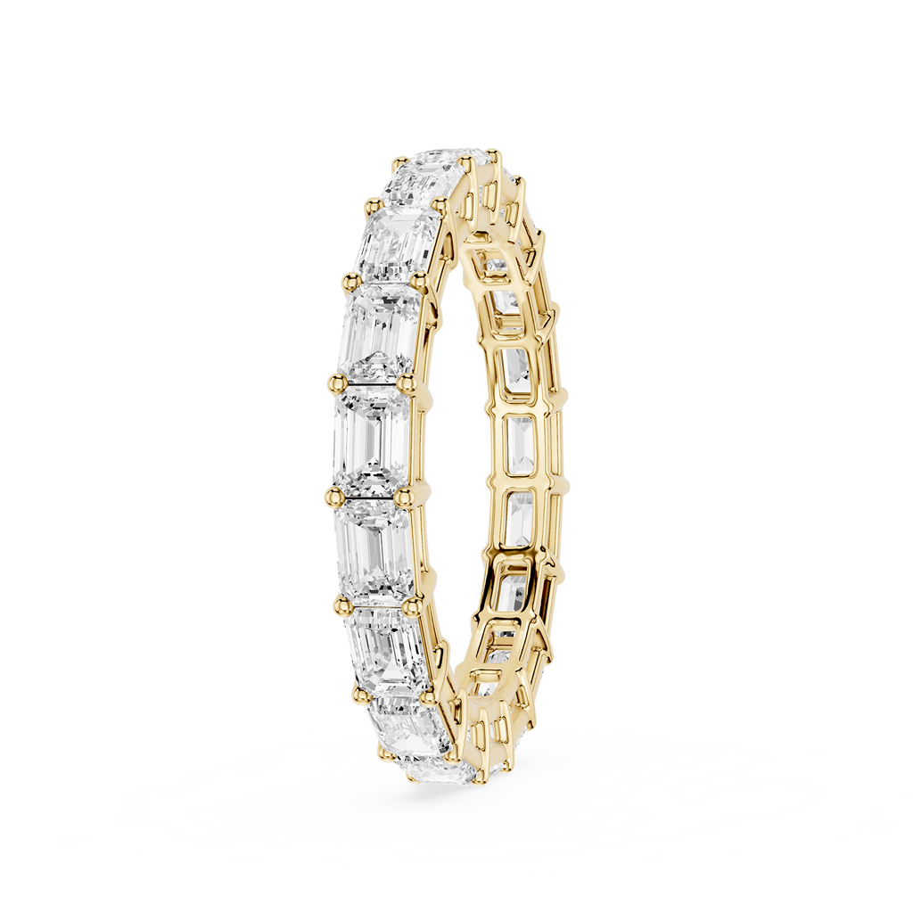 A yellow gold eternity ring featuring a continuous row of clear baguette-cut gemstones, shown on a plain white background.