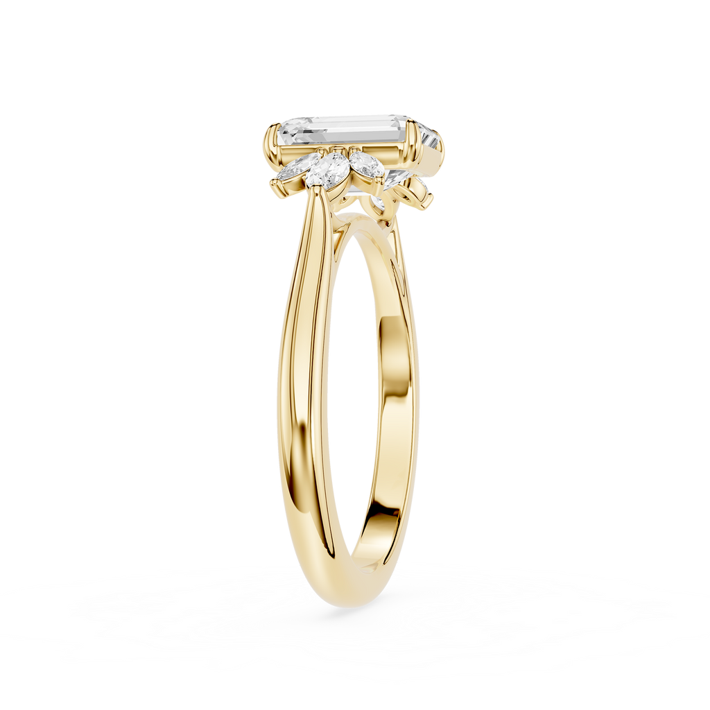 A yellow gold ring featuring a baguette-cut clear center stone and three marquise-cut side stones, shown on a plain white background.