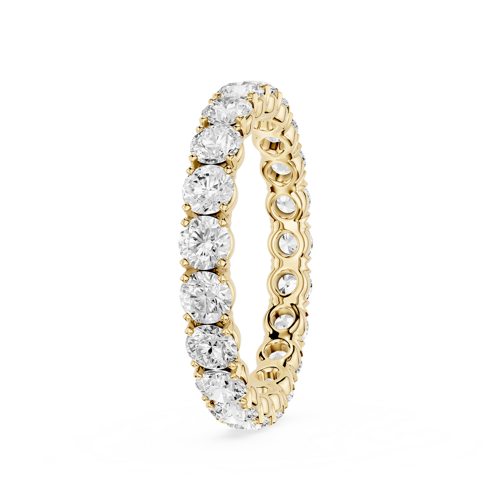 A yellow gold eternity ring featuring a continuous row of round brilliant-cut diamonds on the front and smaller pave-set diamonds on the inner band, shown on a clean white background.