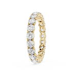 A yellow gold eternity ring featuring a continuous row of round brilliant-cut diamonds on the front and smaller pave-set diamonds on the inner band, shown on a clean white background.