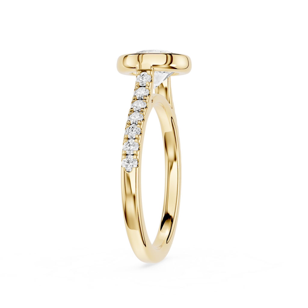 A yellow gold ring with a pavé diamond shank, featuring a round bezel-set top and a curved row of clear diamonds on the band, shown against a plain white background.