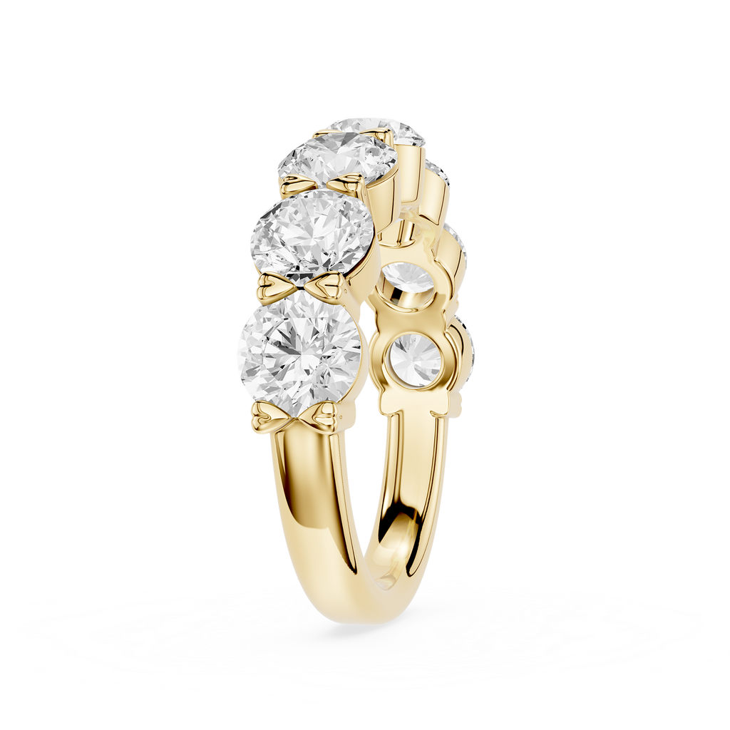 A yellow gold ring featuring a cluster of round brilliant-cut clear gemstones on the top, with smaller accent stones on the side, set against a plain white background.
