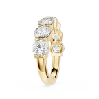 A yellow gold ring featuring a cluster of round brilliant-cut clear gemstones on the top, with smaller accent stones on the side, set against a plain white background.