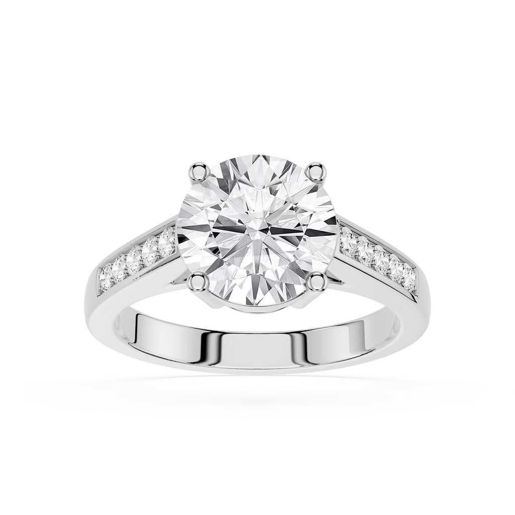 A round-cut diamond solitaire engagement ring with a silver-colored band featuring pavé-set diamonds on the shoulders, shown on a clean white background.
