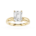 Gold ring with a large emerald-cut diamond on a white background