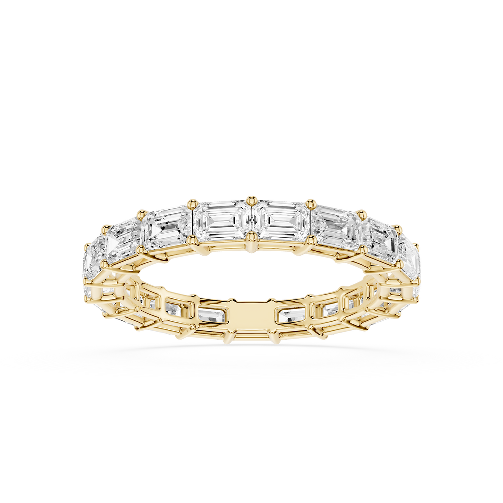 A Yellow gold eternity ring featuring a continuous line of baguette-cut clear gemstones, shown on a clean white background.