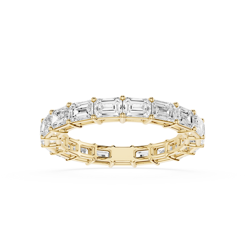 A Yellow gold eternity ring featuring a continuous line of baguette-cut clear gemstones, shown on a clean white background.