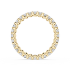 A yellow gold eternity ring featuring a continuous row of small, scalloped-cut clear gemstones, presented on a clean white background.