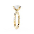 A yellow gold solitaire engagement ring featuring a triangular clear gemstone in a four-prong setting, with a shank accented by small channel-set diamonds, shown on a plain white background.