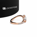 Twisted split shank diamond ring in rose gold with a round brilliant center stone and curved diamond accented shoulders
